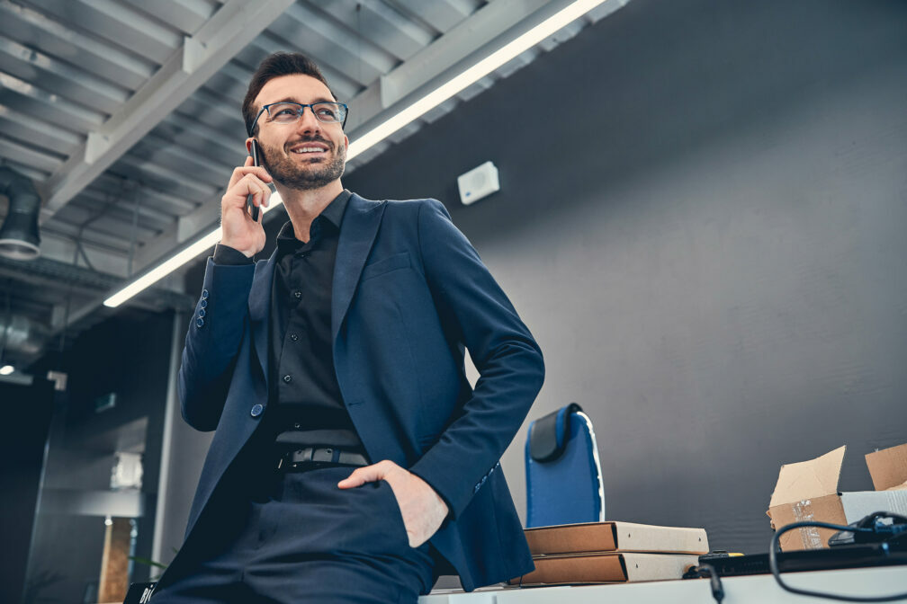 Positive male making call to his partner while holding hand in the pocket